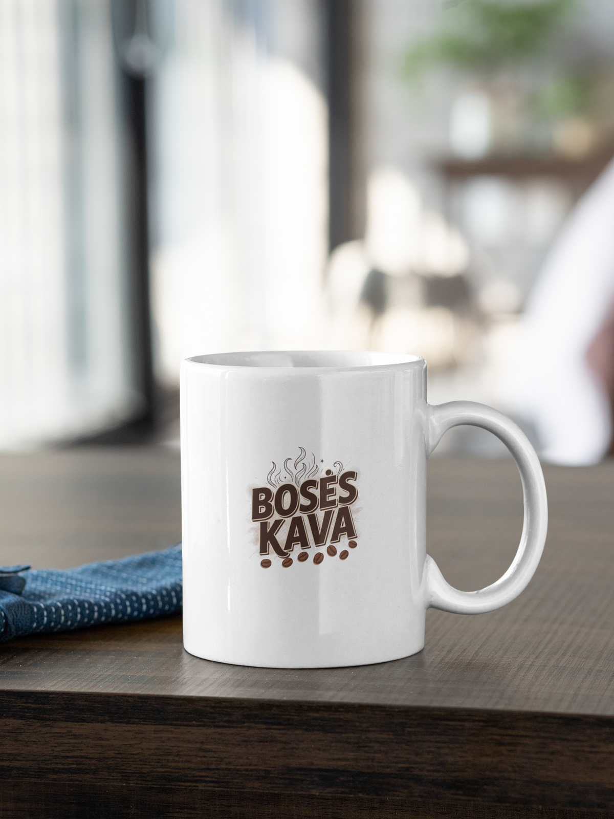 Baltas puodelis su užrašu "BOSĖS KAVA" su piešiniu.